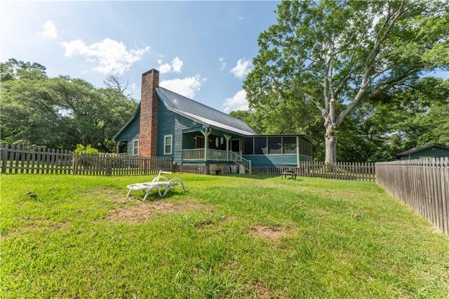 view of yard with a fenced backyard and a sunroom