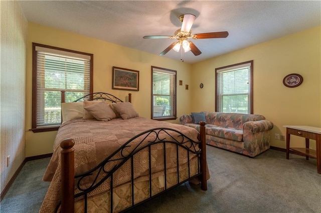 carpeted bedroom featuring baseboards and ceiling fan