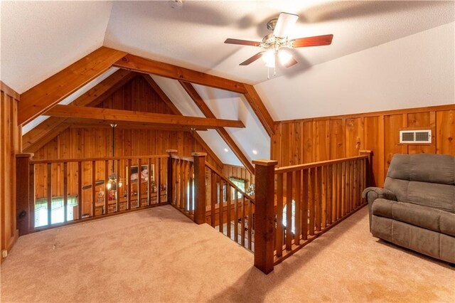bonus room featuring visible vents, wood walls, lofted ceiling, a ceiling fan, and carpet