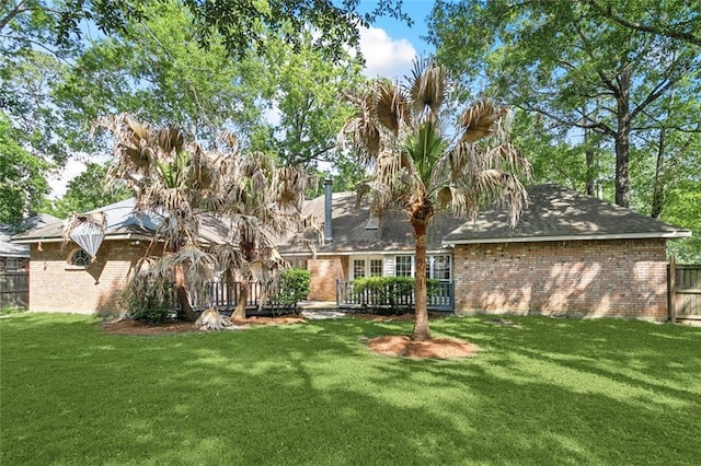 6024 Chateau Loire Cir, Mandeville, LA 70448 - back of property featuring a lawn, fence, and brick siding
