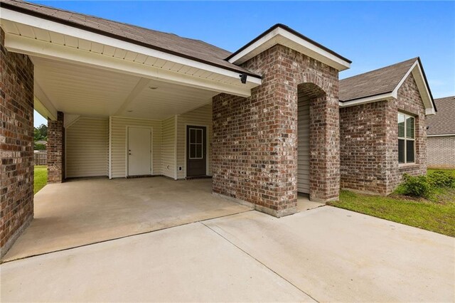 48345 Red Fox Dr, Hammond, LA 70401 - view of front of house featuring brick siding, driveway, roof with shingles, and a carport