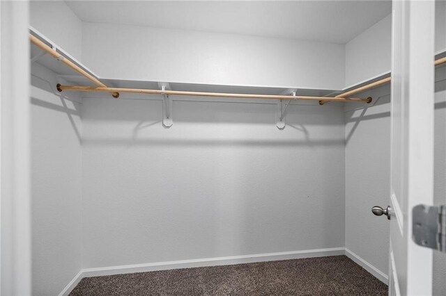 48345 Red Fox Dr, Hammond, LA 70401 - empty room with dark colored carpet, baseboards, lofted ceiling, and a smoke detector