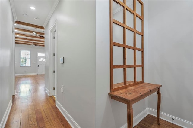 hallway featuring baseboards, beamed ceiling, recessed lighting, and wood finished floors