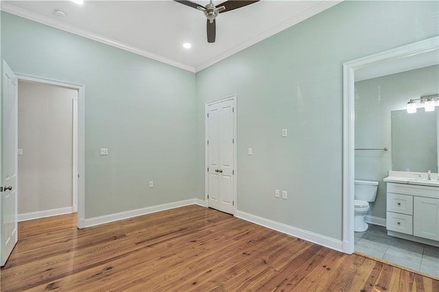 unfurnished bedroom with baseboards, ornamental molding, and light wood finished floors
