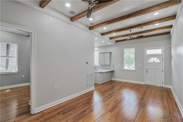 foyer with a ceiling fan, baseboards, wood finished floors, beamed ceiling, and visible vents