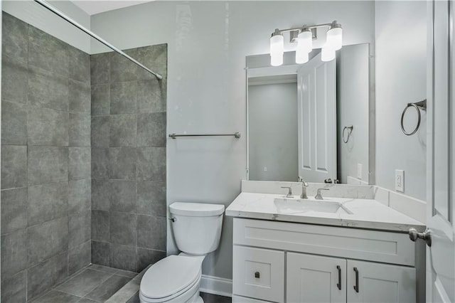 full bath featuring vanity, toilet, and tiled shower