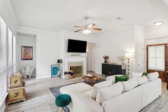 23284 Burvant St, Abita Springs, LA 70420 - living area featuring ceiling fan, light wood-style flooring, ornamental molding, a fireplace, and baseboards