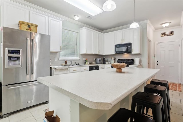23284 Burvant St, Abita Springs, LA 70420 - kitchen featuring black appliances, ornamental molding, light tile patterned floors, a breakfast bar area, and light countertops