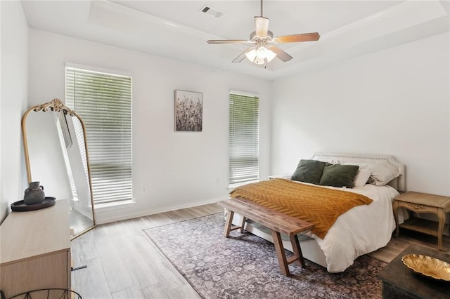 23284 Burvant St, Abita Springs, LA 70420 - bedroom featuring a tray ceiling, wood finished floors, ornamental molding, ceiling fan, and baseboards