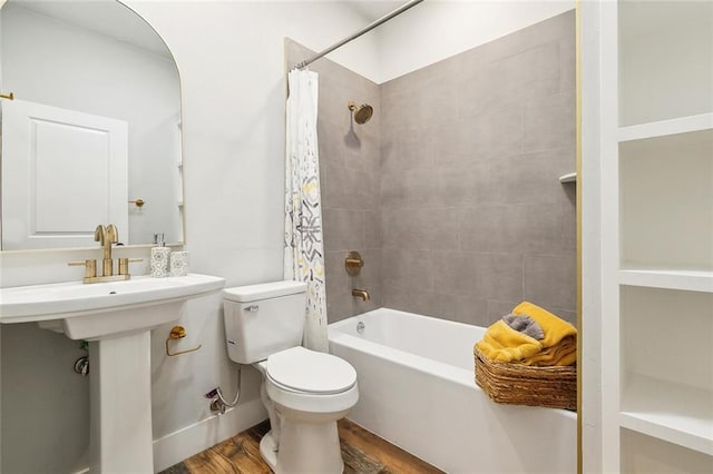 bathroom with toilet, wood finished floors, and shower / tub combo