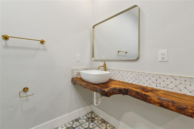 bathroom featuring baseboards and a sink