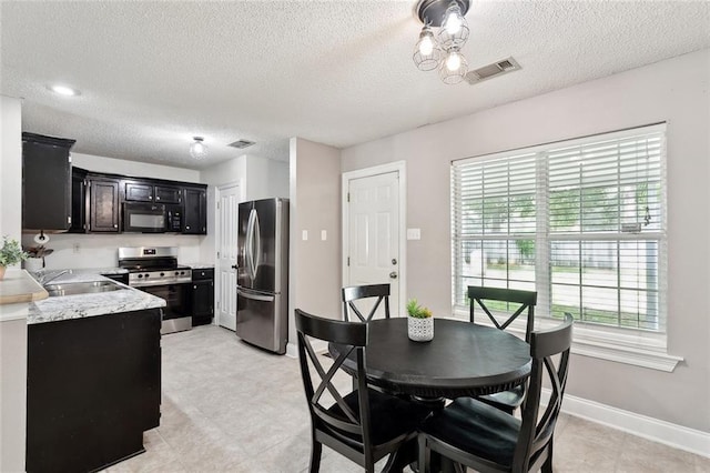 dining room featuring visible vents, a textured ceiling, and baseboards