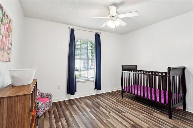 bedroom with a textured ceiling, baseboards, and wood finished floors