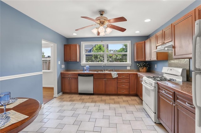 5652 General Haig St, New Orleans, LA 70124 - kitchen featuring brown cabinetry, white appliances, ceiling fan, under cabinet range hood, and a sink