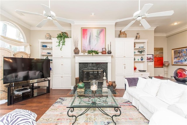living area featuring a ceiling fan, dark wood-style floors, crown molding, a premium fireplace, and recessed lighting