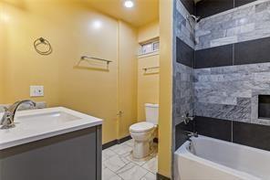 full bath featuring toilet, bathtub / shower combination, tile patterned flooring, and vanity