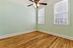 spare room featuring baseboards, a ceiling fan, and wood finished floors