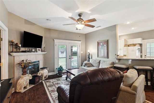 living room featuring a ceiling fan, recessed lighting, wood finished floors, a tile fireplace, and visible vents