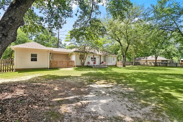 rear view of house with a yard and fence