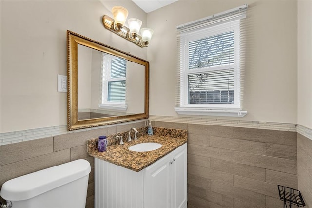 809 Oakwood Dr, Terrytown, LA 70056 - bathroom with vanity, wainscoting, toilet, and tile walls