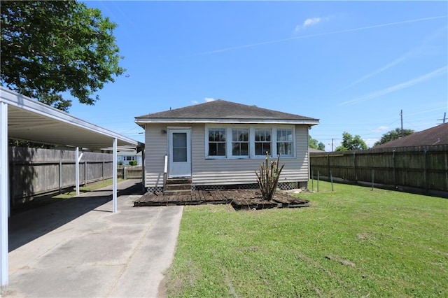 exterior space featuring a fenced backyard, a carport, a yard, and entry steps