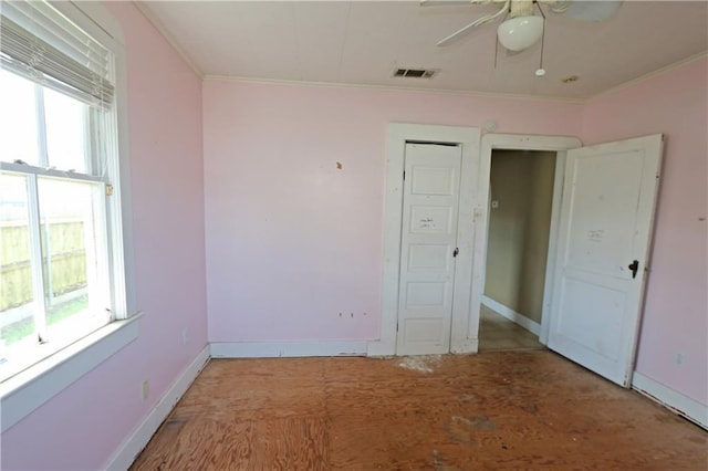 unfurnished bedroom with visible vents, ornamental molding, baseboards, and multiple windows