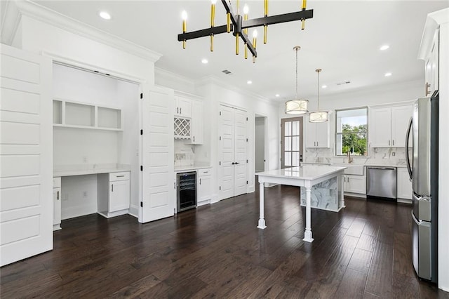 kitchen featuring crown molding, beverage cooler, dark wood-style floors, a sink, and appliances with stainless steel finishes