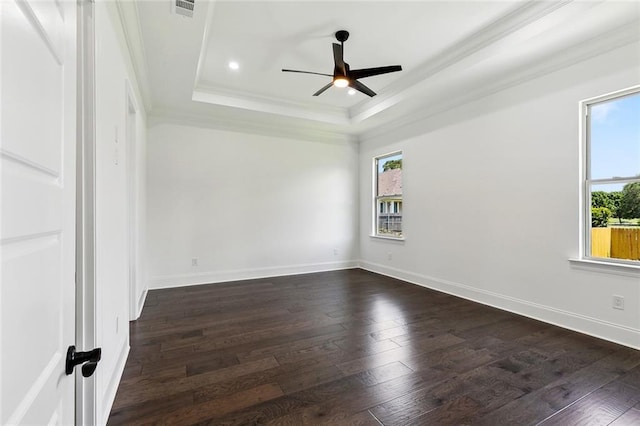 unfurnished room with crown molding, ceiling fan, dark wood finished floors, and a raised ceiling