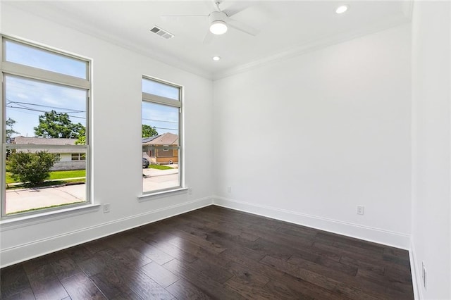 spare room featuring ceiling fan, dark wood finished floors, baseboards, visible vents, and ornamental molding