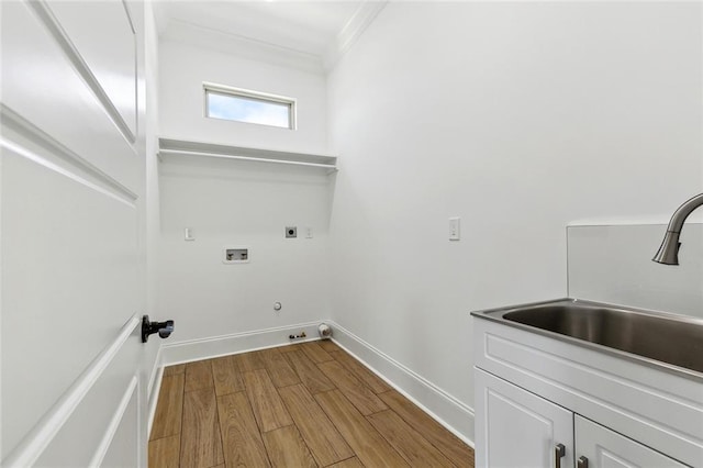 clothes washing area featuring electric dryer hookup, cabinet space, wood finished floors, a sink, and hookup for a washing machine