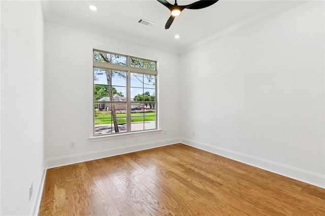 unfurnished room with ceiling fan, baseboards, wood finished floors, visible vents, and ornamental molding