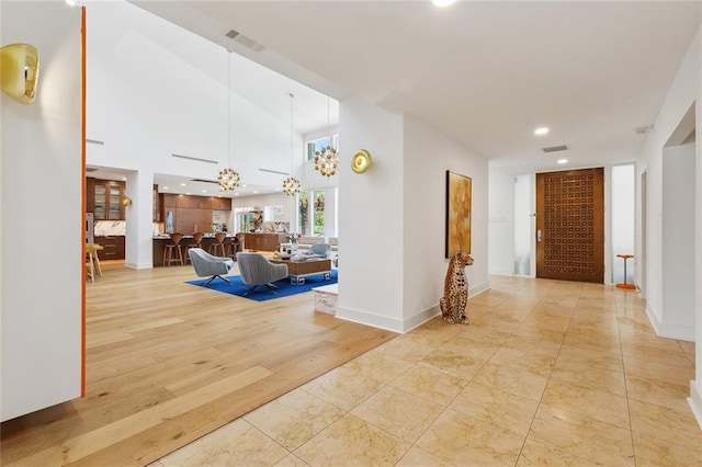 corridor with visible vents, recessed lighting, baseboards, and a chandelier