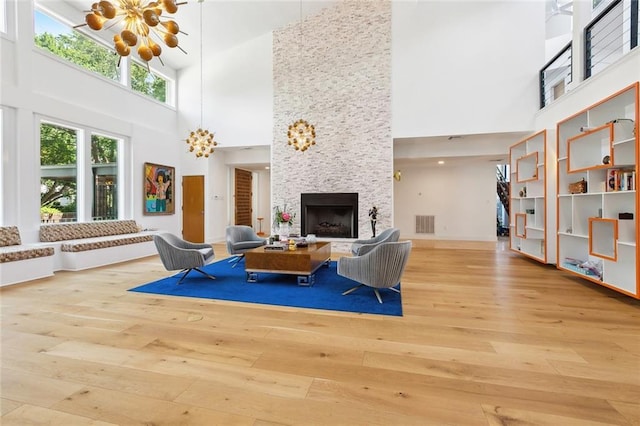 living area featuring an inviting chandelier, hardwood / wood-style flooring, and a towering ceiling