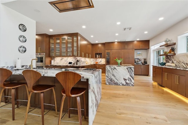 kitchen with visible vents, decorative backsplash, recessed lighting, and light stone countertops