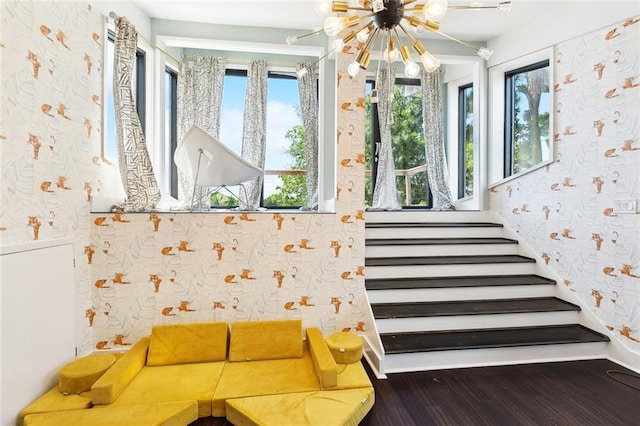interior space with wallpapered walls, a chandelier, wood finished floors, and stairway