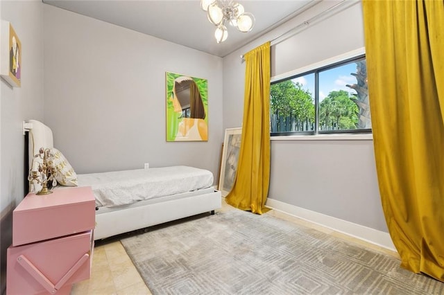 bedroom featuring an inviting chandelier and baseboards