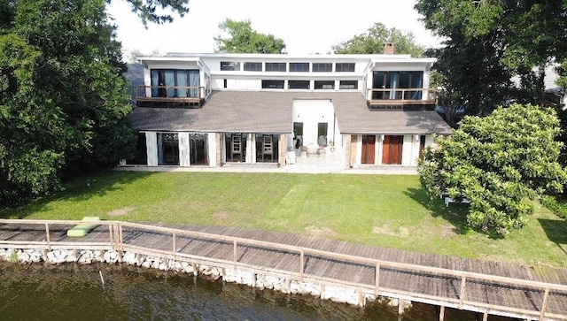 5640 Bancroft Dr, New Orleans, LA 70122 - back of property featuring a water view, a lawn, and a chimney