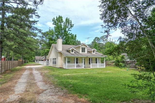 rear view of house featuring fence, covered porch, a yard, and driveway