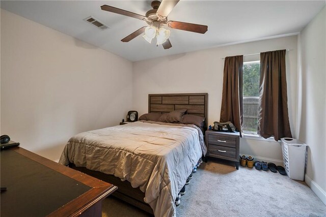 carpeted bedroom with a ceiling fan, baseboards, and visible vents