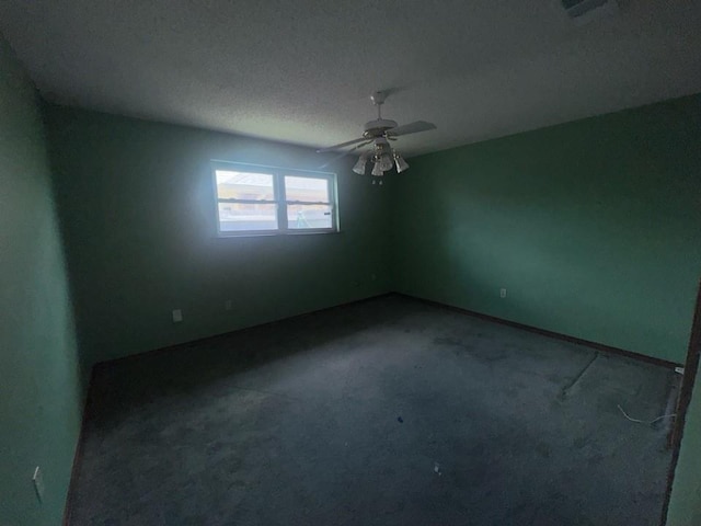 spare room featuring carpet floors, a ceiling fan, a textured ceiling, and visible vents