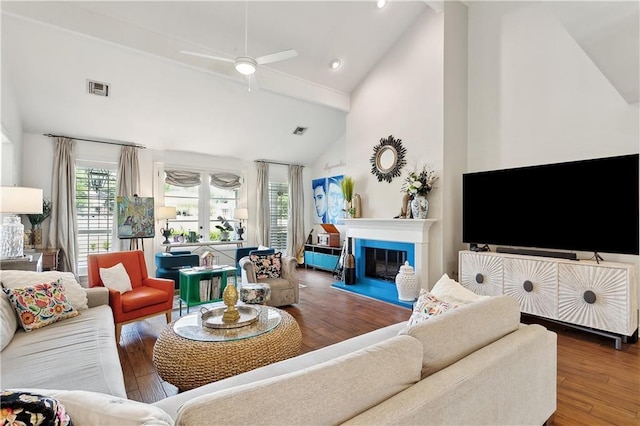 living room featuring wood finished floors, a ceiling fan, beam ceiling, and visible vents