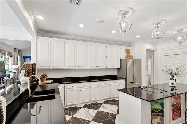 kitchen featuring visible vents, dark countertops, a sink, freestanding refrigerator, and marble finish floor