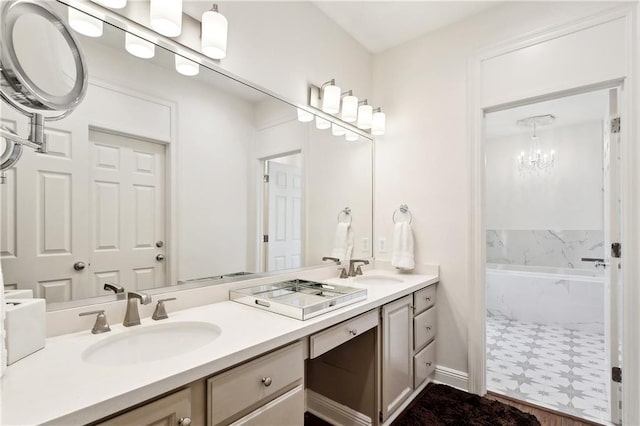 full bath with double vanity, a sink, an inviting chandelier, and a tub with marble appearance