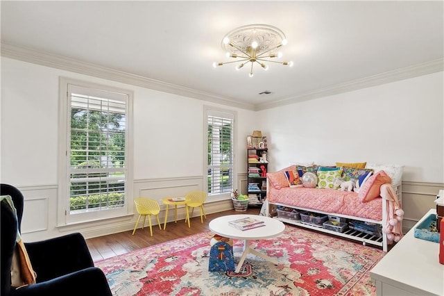 bedroom featuring crown molding, wood finished floors, a chandelier, and a wainscoted wall