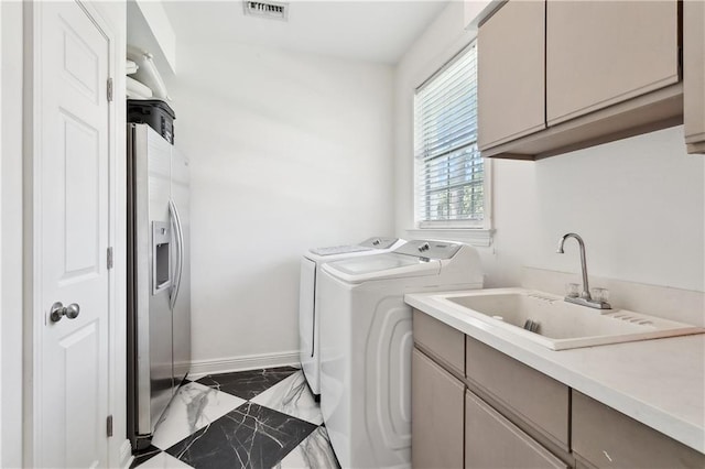 clothes washing area featuring visible vents, marble finish floor, washer and clothes dryer, a sink, and cabinet space