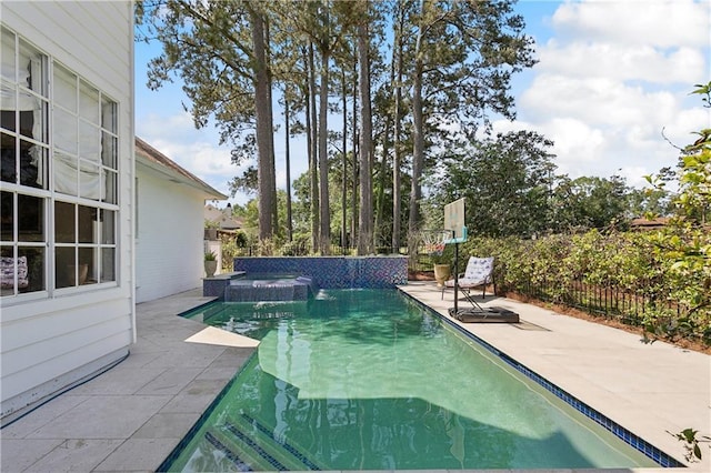 outdoor pool with fence and a patio area