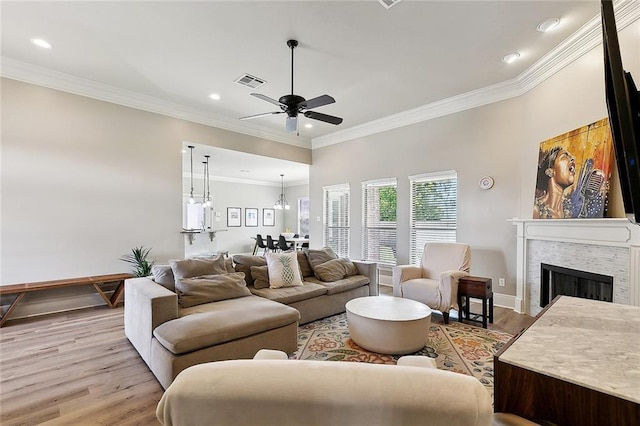 living room featuring visible vents, ceiling fan, recessed lighting, a tiled fireplace, and light wood-style flooring