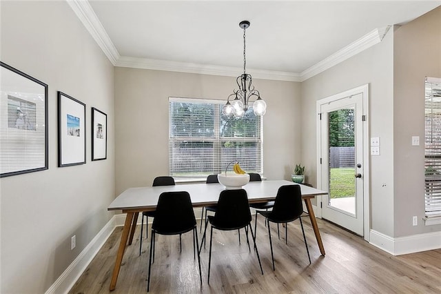 dining area with crown molding, baseboards, a notable chandelier, and light wood-style floors