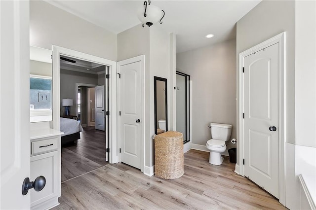 bathroom featuring wood finished floors, toilet, baseboards, recessed lighting, and a shower stall