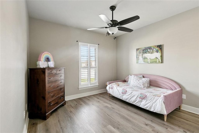 living area with a ceiling fan, baseboards, and wood finished floors